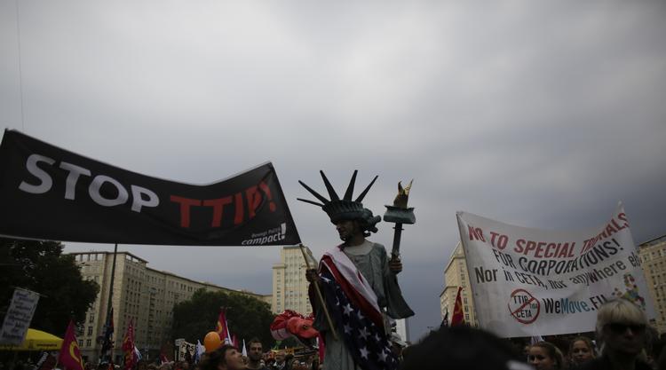 FRIHESDSGUDINDEN på stylter dannede par med Moder Europa i protest mod frihandelsaftalerne i Berlin. 