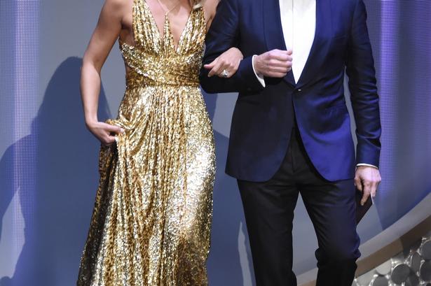 Claire Danes og Bryan Cranston arm i arm på vej på scenen for at overrække en Emmy. 