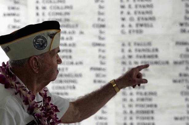 George Bennett overlevede angrebet på skibene i Pearl Harbor. Han var med til 65 årsdagen for 10 år siden. På tavlen udpeger han en falden kammerat. 