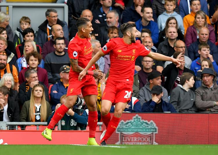KASSE. Adam Lallana og holdkammerat Roberto Firmino fejrer først nævntes scoring til 1-0 på Anfield. 
