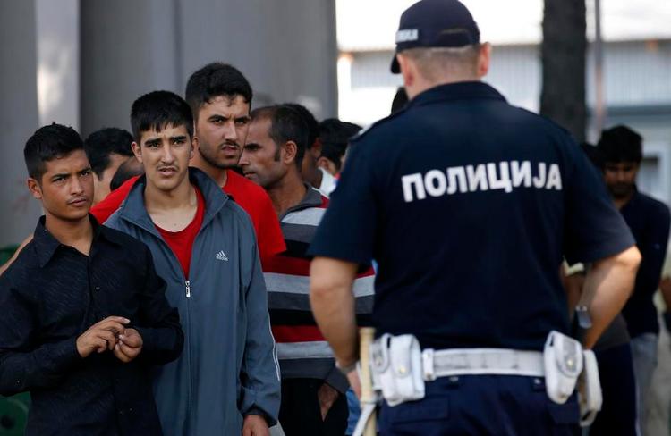 grænsevagt. EU skal have ansvaret for unionens ydre grænser, mener Anders Fogh Rasmussen. Her holder en serbisk betjent styr på en gruppe flygtninge. 