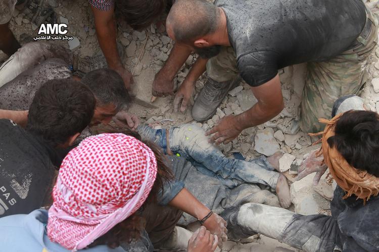Massakre. Civile nødhjælpere bjerger et børnelig ud af ruinerne i Aleppo efter voldsomme bombeangreb fredag. 