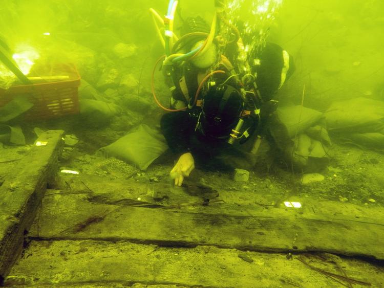 Fund. Marinarkæologer i færd med blotlægge det 750 år gamle skib. 