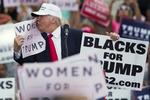 Kysseri. Donald Trump i fysisk nærkontakt med et skilt med teksten »Kvinder for Trump« under et vælgermøde i går i Florida. 