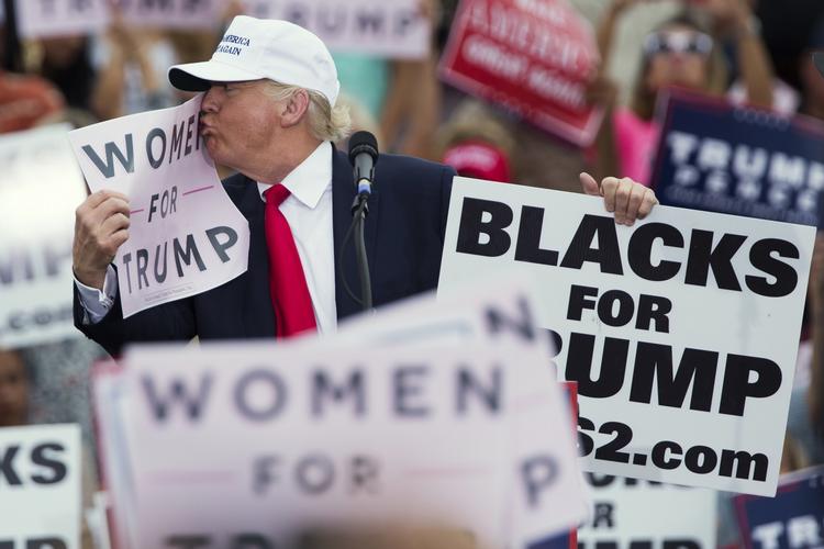 Kysseri. Donald Trump i fysisk nærkontakt med et skilt med teksten »Kvinder for Trump« under et vælgermøde i går i Florida. 