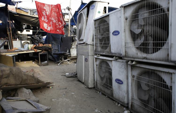 KLIMAFORANDRINGER En indisk dreng sover i bagende varme ved siden af airconditionanlæg til salg på et marked i New Delhi. I går indgik 150 lande en aftale om at udfase HFC-gasser, som blandt andet kommer fra aircondition. 
