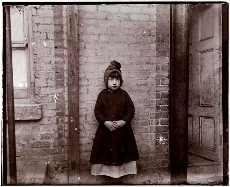 SLUMLIV. Skrubbersken Katie på 9 år, som Riis mødte i 1888. Mange indvandrere levede stuvet sammen i små overfyldte rum, mens drømmen om et nyt liv i den nye verden gik op i limningen. 