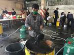 MØRKELAGT. Mange steder i Thailand kan folk komme med deres tøj og gratis få det farvet sort. Her er der stillet udstyr frem i et firma, der ellers handler med traktorer. Foto: Natnicha Chuwiruch/AP 