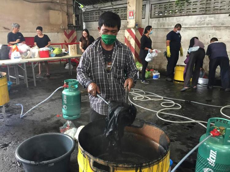 MØRKELAGT. Mange steder i Thailand kan folk komme med deres tøj og gratis få det farvet sort. Her er der stillet udstyr frem i et firma, der ellers handler med traktorer. Foto: Natnicha Chuwiruch/AP 