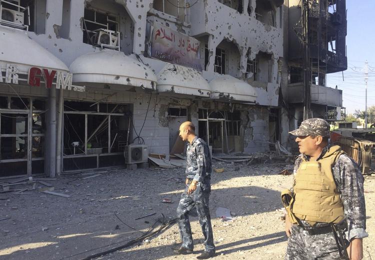 murbrokker Irakisk militær inspicerer lørdag ødelæggelser af byen Kirkuk, 170 kilometer syd for Mosul, efter at kamphandlinger, tilsyneladende en distraktionsmanøvre fra Islamisk Stat, brød ud fredag og lørdag. 