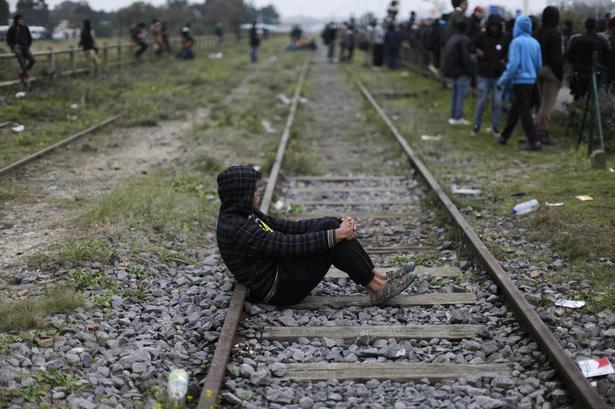 En ventende migrant hviler lidt foran registreringsbordene. Han kan vælge at søge asyl i Frankrig. Gør han ikke det, risikerer han at blive sendt tilbage til hjemlandet. 