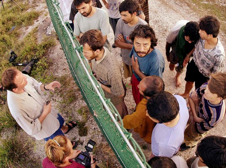 ASYL Flygtninge i en lejr i Nauru bliver interviewet af journalister gennem hegnet. Menneskerettighedsgrupper har anklaget Australien for at igennem fingre med menneskerettighedskrænkelser i lejrene. Arkivfoto fra 2001. 