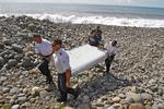 Bevis. Politifolk bærer et stykke af en vinge ved Mauritius' kyst. Det blev senere fastslået, at vragdelen stammede fra det forsvundne fly MH370. 