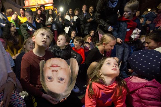 OMVENDT I en forstad til New York holder en dreng en papfigur af Hillary Clintons ansigt, mens en valgkamp, der vender op og ned på  amerikansk politik viser sig på skærmen. 
