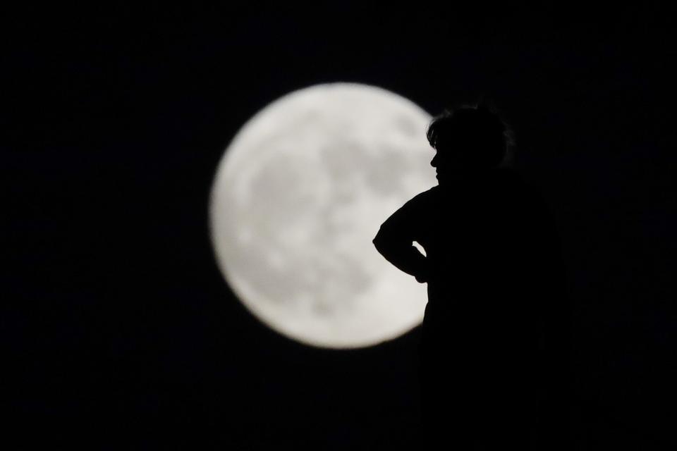 En kvinde står i silhouet mod den flotte måne over La Habra i Californien. 