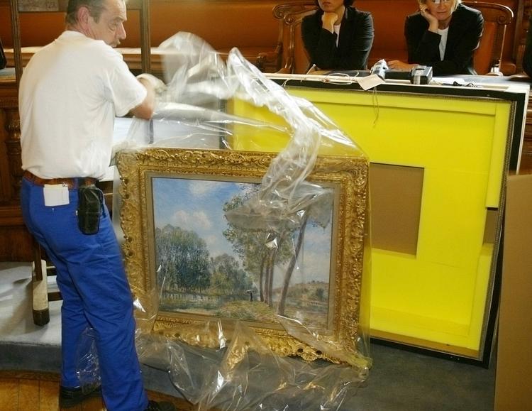 Tyvekost. På dette billede fra 2004 ses maleriet 'Soleil de Printemps, Le Loing' af den franske maler Alfred Sisley blive pakket ud. Frankrig er også et af de 44 lande, der har underskrevet Washington-principperne om at opspore stjålet kunst. Arkivfoto: AP Photo/Michel Euler 