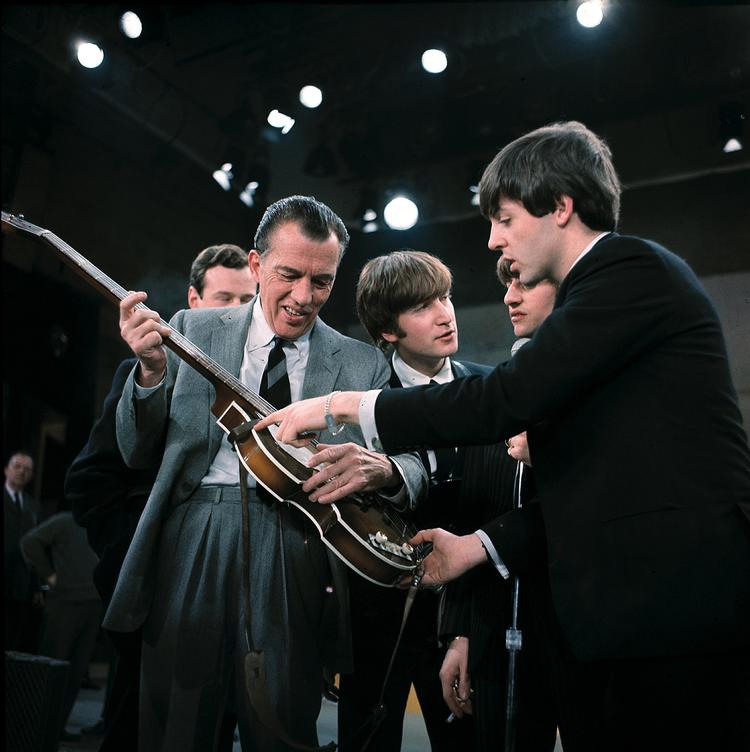 Paul McCartney viser sin guitar til tv-vært Ed Sullivan inden en optræden på 'The Ed Sullivan Show', 1964. 