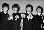 The Beatles flash'er deres kongelige ordener, som de fik overrakt af den britiske dronning i 1965. 