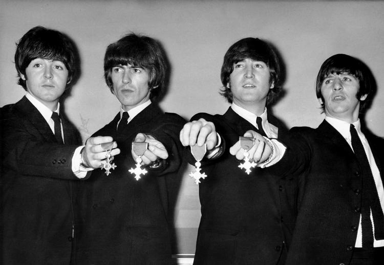 The Beatles flash'er deres kongelige ordener, som de fik overrakt af den britiske dronning i 1965. 