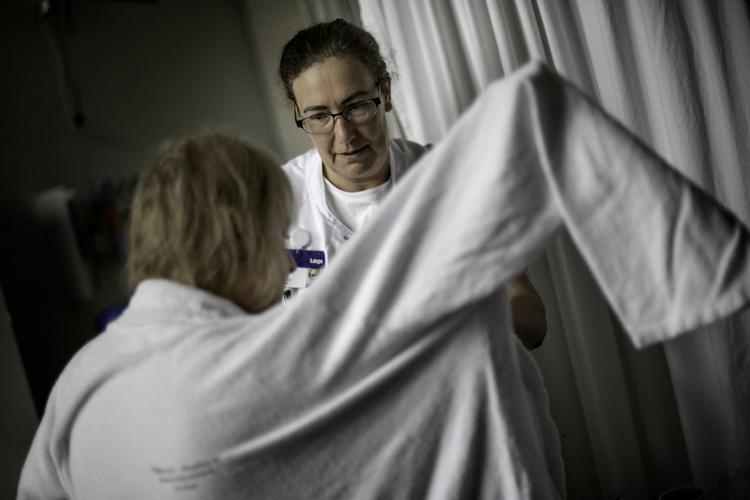 Overlæge Hanne Christensen har fundet en noget stor housecoat frem til den dame, der dagen før blev indlagt med en blodprop i hjernen. Medisinsk behandling har opløst proppen, og patienten har det nogenlunde. PETER KLINT /POLFOTO