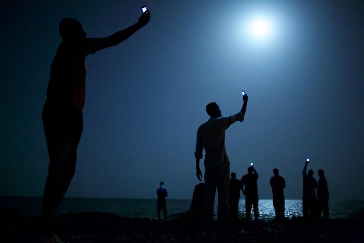 Vinder. Årets vinder af World Press Photo har ikke manipuleret med sit billede af migranter i Djibouti, der forsøger at fange signaler på deres mobiltelefoner. John Stanmeyer for VIII Agency