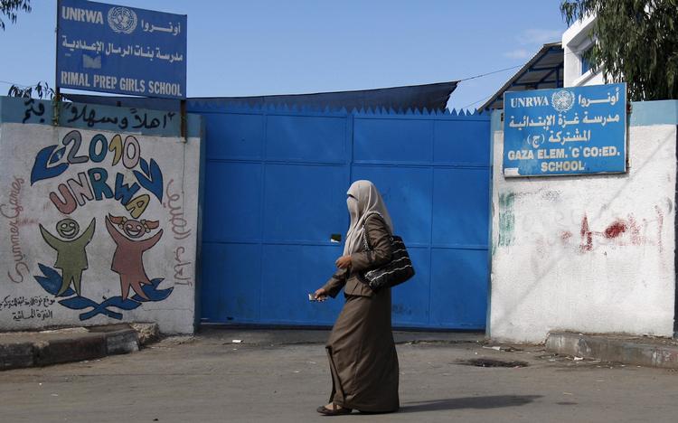 En palæstinensisk lærer går forbi indgangen til en UNRWA-skole i Gaza.   Arkivfoto:  ADEL HANA (Arkiv)