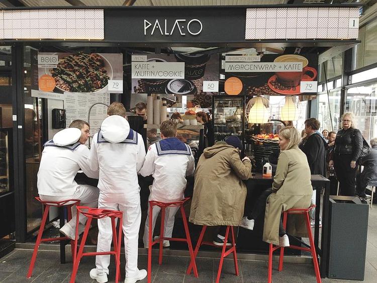 Protein-Power. Det er torsdag, og Palæo, stenalderkost-cafeen i Torvehallerne, er fyldt med kunder, der bestiller hotdogs, hvor brødet er lavet af æggekage, og spaghetti bolognese, hvor spaghettien er erstattet af grøntsagsstrimler. 
