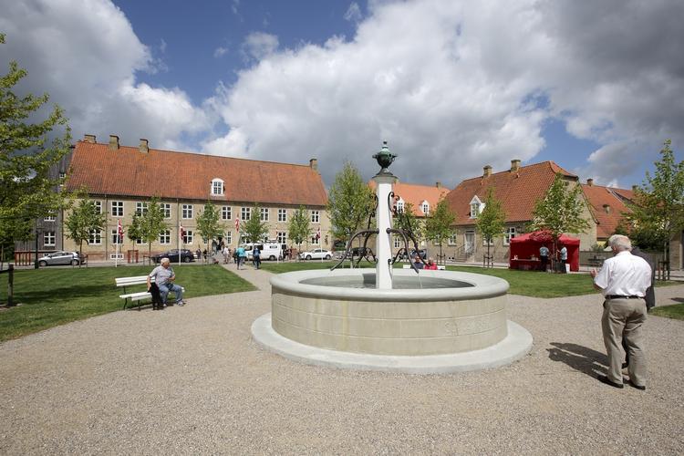 Verdensarv. Den centrale bymidte i Christiansfeld med de karakteristiske gule murstenshuse i enkel byggestil. Brønden på billedet er det centrum, hvorfra hele byen blev planlagt. 