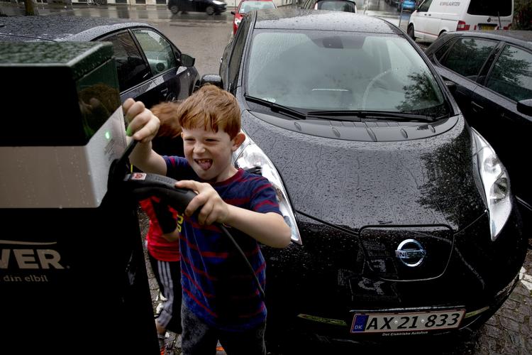 FREMTIDEN. I udlandet satser man hårdt på at fremme elbilerne gennem afgiftspolitikken og ved hjælp af tilskud. Herhjemme er salget af elbiler gået helt i stå efter at Danmark har indført afgifter på elbiler i modsætning til vores nabolande. Her er Anders Sloths sønner Villads og Gilbert ved at tanke famliens elbil. Som en af de få, har Frederiksbergfamlien nemlig købt deres egen elbil. 