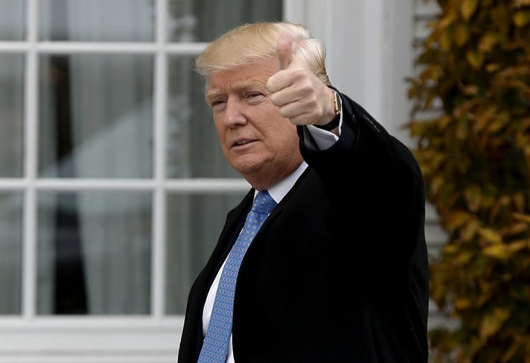 Trump hilser på medierne ved et besøg på en af sine egne golfklubber i november. 