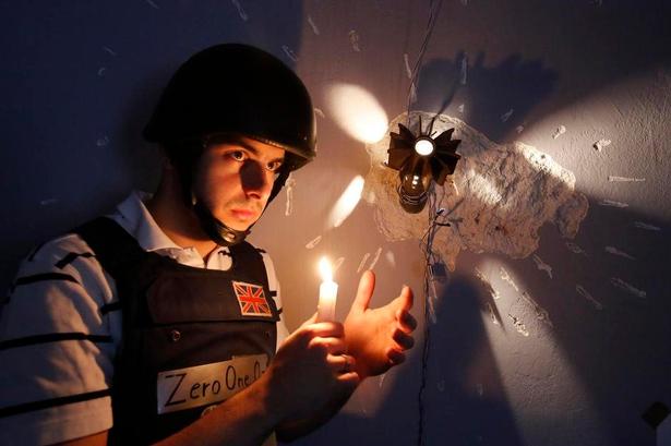 Værten Zero One demonstrerer lyskilderne: En nøgen lampe og stearinlys. 