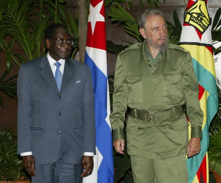 Fidel Castro overdrog først magten til sin lillebror Raul Castro i 2008, da han gennem længere tid havde været svækket af sygdom. Her ses Fidel Castro sammen med Zimbabwes jævnaldrende despot, Robert Mugabe. (Foto: AP) 