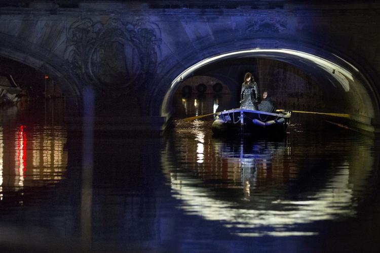 Dødsgudinden. Pludselig kommer en lille lysende jolle padlende ud af mørket med en spinkel kvindeskikkelse som styrmand. 