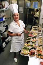 Ida Davidsen i sit rette element. Uniformeret med en gammel smørekniv i gang med at anrette smørrebrød. 