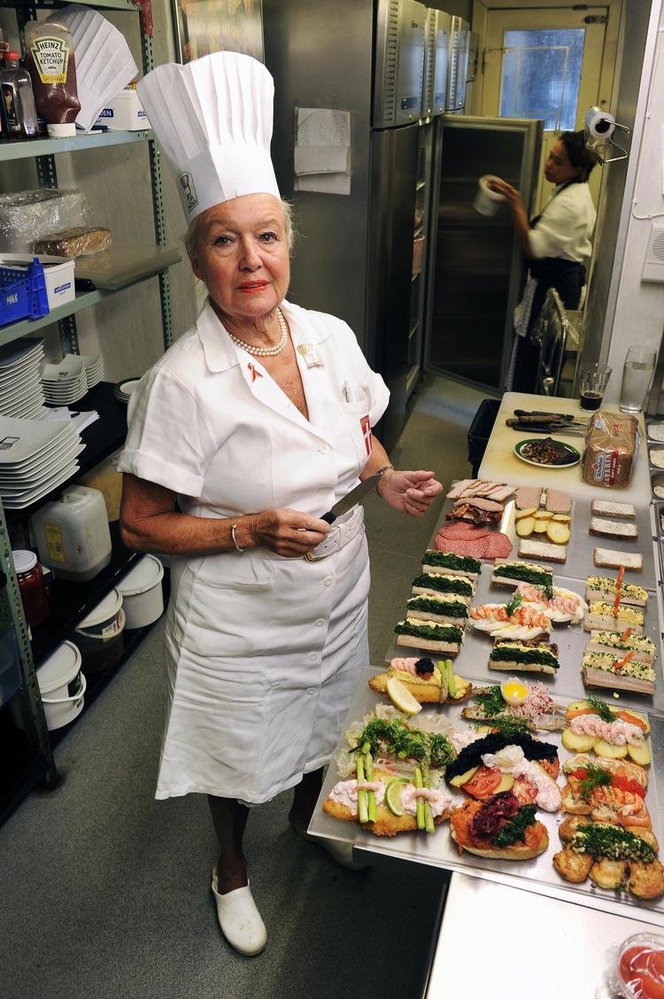 Ida Davidsen i sit rette element. Uniformeret med en gammel smørekniv i gang med at anrette smørrebrød. 