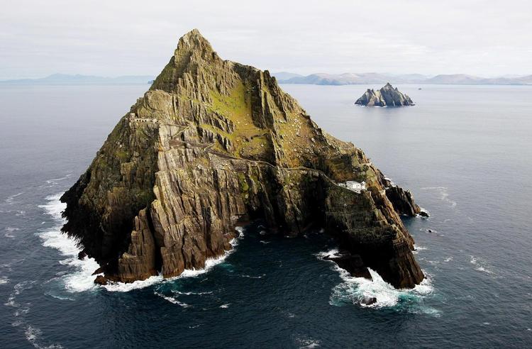 Skellig Michael skyder op i Atlanterhavet. Efter århundreder, hvor øen var beboet af munke, blev den et mål for pilgrimsrejser. I baggrunden ses Little Skellig og Irlands fastland. 