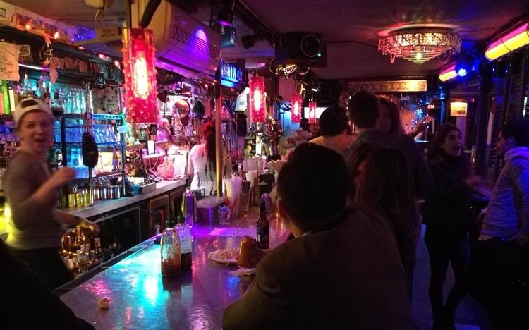 På en af New York's mange barer, 169 Bar, er Loftslyset violet, popmusikken høj, og barens gæster lige dele brogede og festlige. 