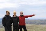 På toppen af Mount Kosciuszko er blæsten ekstrem. Det gælder om at holde fast i hinanden, så man ikke vælter omkuld, mens fotografen tager et hurtigt billede. 