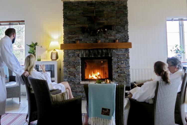 Flere gæster i spaafdelingen satte sig til rette foran pejsen. The Lodge er gennemtænkt til mindste detalje, og selv tæpperne har mærker med hotellets logo på. 