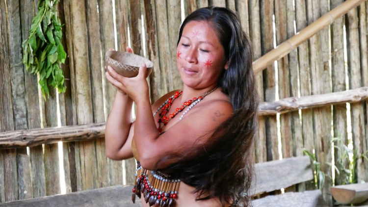 I en lille landsby ved Amazonfloden i Ecuador danser de lokale en indfødt dans. 