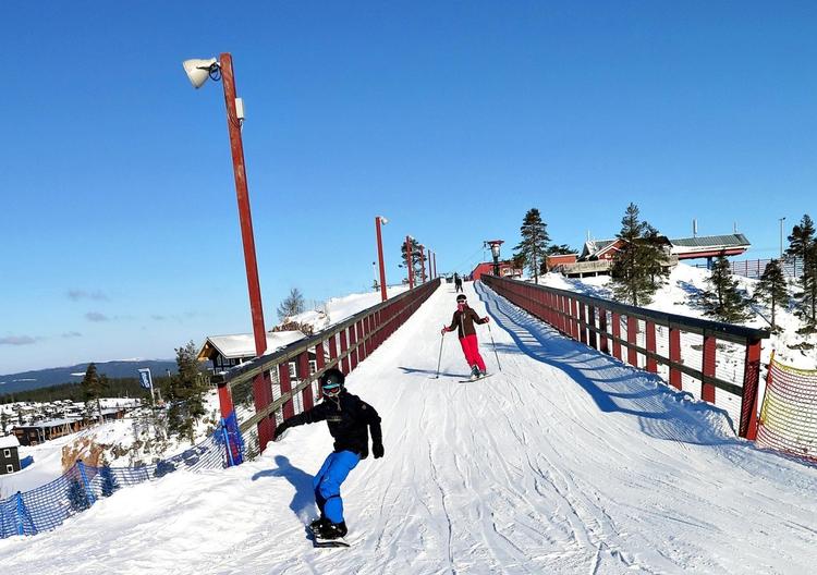 Solens skygge udgør et fint spejl, så den unge snowboarder kan følge sin formåen på pisten. 