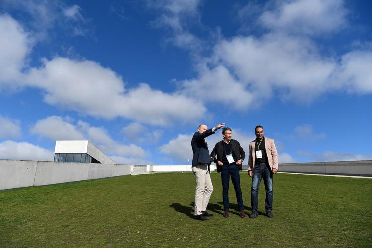 Halvvejs oppe af Moesgård Museums karakteriste skrånende græstag stopper Jakob Larsen (til venstre), direktør i Dansk Atletik Forbund, op for sammen med Aarhus Kommunes kulturrådmand, Rabih Azad-Ahmad (R), at vise Sebastian Coe (i midten), præsident for Det Internationale Atletikforbund, dele af ruten ved VM Cross Country 2019, der skal finde sted i skovene ved Aarhus. Foto: Lars Møller/Dansk Atletik Forbund 