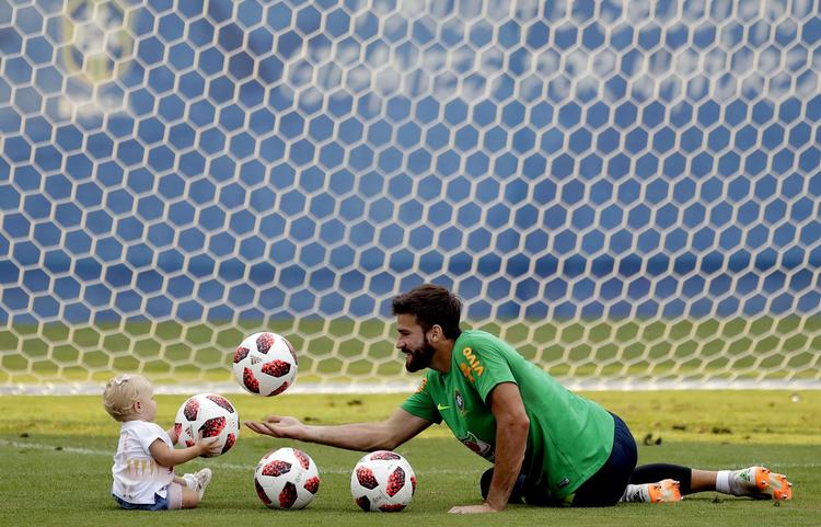Alisson havde sin datter Helena med sig på træningsbanen i Sotji og lærte hende lidt om, hvordan man håndterer VM-bolden.   /AP